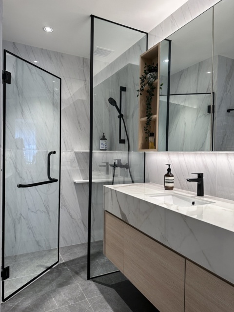 Łazienka z prysznicem i umywalką wykończoną płytami Dekton Vigil kC w polerze.