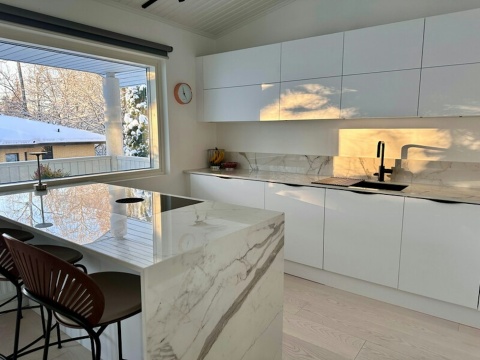 Jasna kuchnia z wyspą i ścianą nad blatem w Dekton Vigil kC w polerze, z eleganckim rysunkiem.