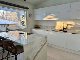 Jasna kuchnia z wyspą i ścianą nad blatem w Dekton Vigil kC w polerze, z eleganckim rysunkiem.