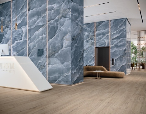 Ściany lobby hotelowego wykończone spiekiem Grespania Alaska Negro Pulido w połysku.