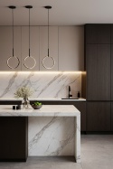 Kuchnia – wyspa i blaty robocze w Calacatta, kontrastujące z ciemnymi lub drewnianymi frontami, z delikatnym podświetleniem LED