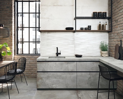 Kuchnia w stylu loftowym z blatem i ścianą z Distrito Aluminio – połączenie betonu, cegły i czarnych akcentów.