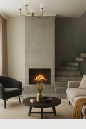 Pomieszczenie relaksacyjne ze spiekiem Titan Cemento, kominek, schody, jasna sofa, ciepłe światło