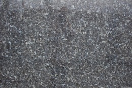 zbliżenie powierzchni kamienia, pokazujące migotanie srebrzystych i niebieskich kryształów oraz naturalną, lśniącą strukturę.