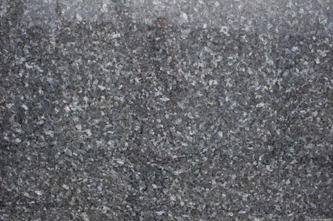 zbliżenie powierzchni kamienia, pokazujące migotanie srebrzystych i niebieskich kryształów oraz naturalną, lśniącą strukturę.