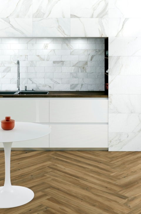 Kuchnia – wyspa i blaty robocze w Calacatta, kontrastujące z ciemnymi lub drewnianymi frontami, z delikatnym podświetleniem LED