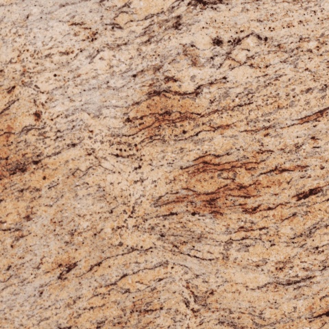 Zbliżenie struktury granitu Shivakashi z beżowo-kremowym tłem i wyraźnymi brązowymi, falistymi żyłkami