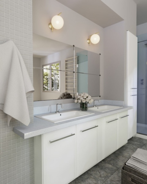 Łazienka z jasnym blatem z aglomarmuru Polare i dwiema umywalkami wpuszczanymi w szafkę