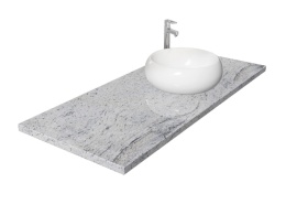 Blat z granitu Kashmir White z nablatową umywalką, o jasnej powierzchni z delikatnym szarym i białym użyleniem
