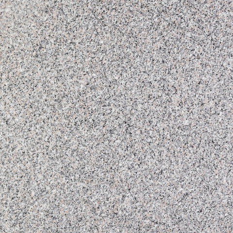 Zbliżenie granitu Rosa Beta o jasnej, drobnoziarnistej strukturze z różowymi i czarnymi wtrąceniami