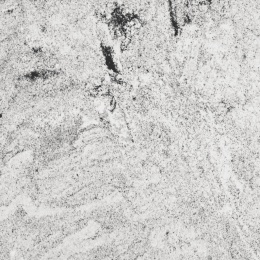 Zbliżenie granitu Viscont White z jasną ziarnistą powierzchnią i wyrazistymi ciemnymi żyłami o naturalnym układzie