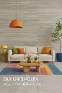 Nowoczesny salon z kolorowymi dodatkami i ścianą ze spieku Silk Gris Poler 120×260 cm o jasnoszarej strukturze.