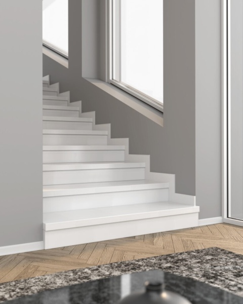 Białe schody wykończone cokołem z konglomeratu kwarcowego Crystal White w nowoczesnym wnętrzu