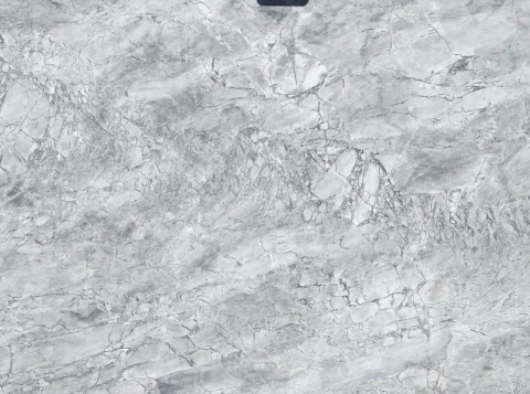 Detal dolomitu Super White, naturalna struktura kamienia z nieregularnymi żyłami i przejściami tonalnymi