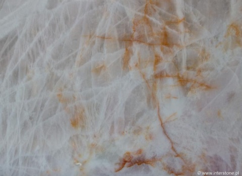 Detal powierzchni Cristallo Rosa WOW z białymi kryształami i rdzawymi przebarwieniami.