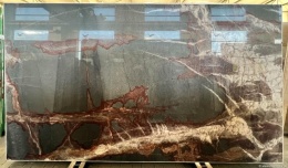 Detal powierzchni Grafite Vitra z intensywnymi czerwono-rdzawymi żyłami na ciemnym tle