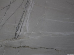 Zbliżenie na strukturę kwarcytu Mont Blanc z delikatnymi szarymi żyłami na jasnym tle.