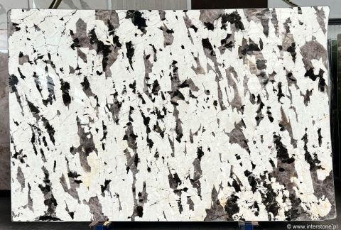 Zbliżenie na strukturę Patagonia Absolut z kontrastem białego kwarcu i ciemnych, nieregularnych minerałów.