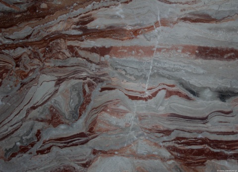 Zbliżenie marmuru Arabescato Orobico Rosso, intensywne czerwono-szare żyłkowanie o falistym układzie.