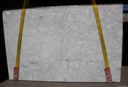 Płyta marmuru Bianco Carrara CD na pasach, jasne tło z równomierną siecią szarych żyłek, widok frontu.