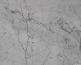 Zbliżenie marmuru Bianco Carrara C, jasnoszare tło z drobnym, nieregularnym szarym użyleniem.