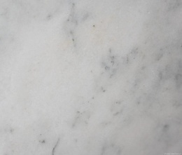 Zbliżenie powierzchni marmuru Bianco Ibiza, jasne tło z delikatnymi szarymi i beżowymi przebarwieniami