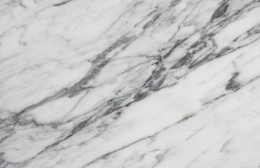Zbliżenie marmuru Bianco Statuarietto, białe tło z wyrazistymi szarymi żyłkami ułożonymi ukośnie