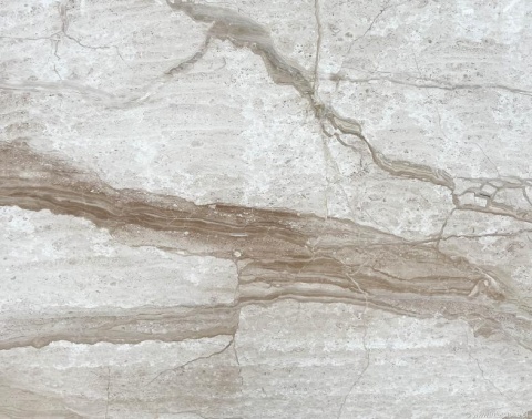 Zbliżenie marmuru Breccia Sarda Venato, jasny beż z szeroką brązową wstęgą i delikatnym użyleniem