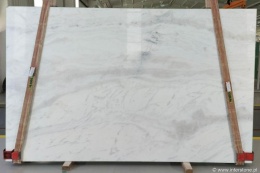 Płyta marmuru Calacatta Berini, jasne tło z delikatnymi szarymi pasmami, widok całego slab w hali