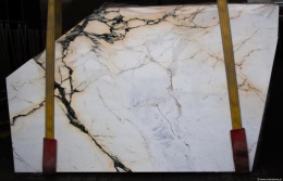 Płyta marmuru Calacatta Paonazzo, jasne tło z mocnym czarno-złotym użyleniem, widok całej tafli.