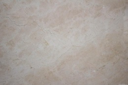 Zbliżenie marmuru Crema Marfil poler – ciepły beż, subtelne żyłki i naturalne chmurki na powierzchni.