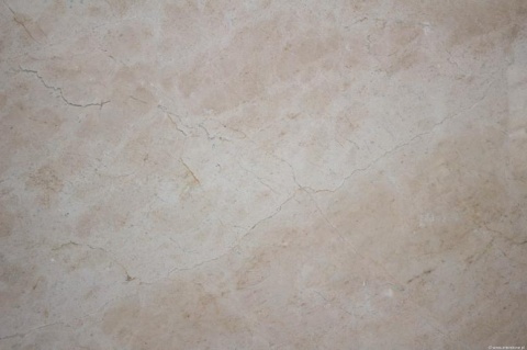 Zbliżenie marmuru Crema Marfil poler – ciepły beż, subtelne żyłki i naturalne chmurki na powierzchni.