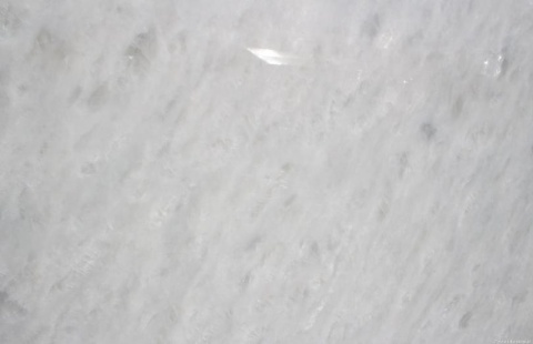 Zbliżenie marmuru Diamond Oniciata – biała płyta z gęstą strukturą drobnych, połyskujących kryształków.