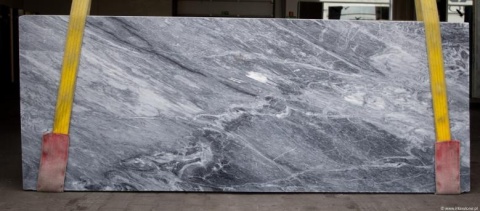 Płyta marmuru Grigio Piemonte, chłodne szarości z miękkim, falistym rysunkiem, widoczna w lekkim skosie.