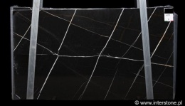 Płyta marmuru Nero Tunezi, głębokie czarne tło z prostymi, złotymi i jasnymi liniami żył.