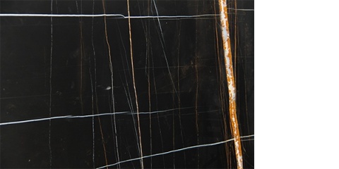 Zbliżenie Nero Tunezi, czarne tło z cienkimi złotymi oraz białymi żyłkami i jedną wyraźną, rdzawą wstęgą.