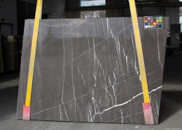 Płyta marmuru Pietra Grey, ciemnoszare tło przecięte pionowymi i skośnymi, cienkimi białymi żyłkami.