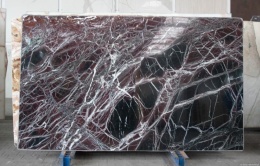 Płyta Rosso Levanto, głęboka czerwień z gęstą siecią białych żyłek i ciemnymi polami kamienia.