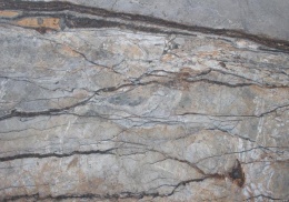 Zbliżenie marmuru Silver River szczotka, nieregularne szare pasma przecięte ciemnymi, cienkimi żyłkami.