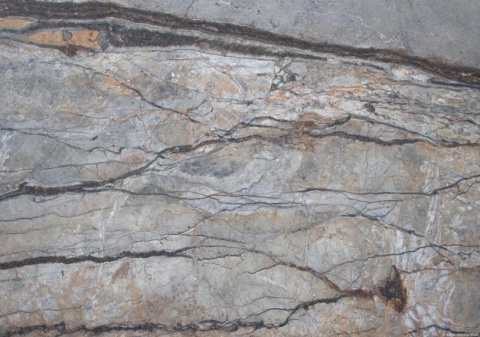 Zbliżenie marmuru Silver River szczotka, nieregularne szare pasma przecięte ciemnymi, cienkimi żyłkami.