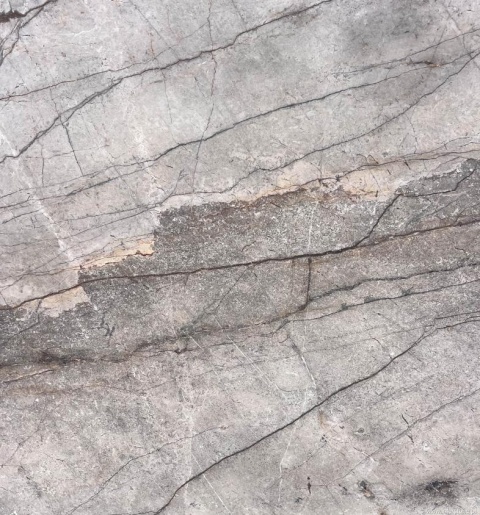 Zbliżenie Silver River poler, szara powierzchnia z warstwowym przejściem tonów i cienkimi, grafitowymi żyłkami.