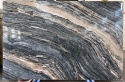 Płyta marmuru Silver Wave, wyraźne, faliste pasma szarości i brązu przypominające przekrój skalnej warstwy.