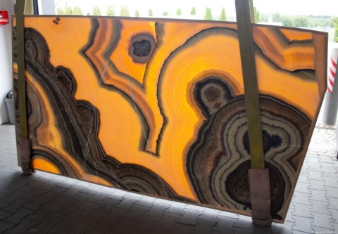 Podświetlany slab onyksu Arco Irys z wyraźnym rysunkiem łuków i kontrastowymi pasami.