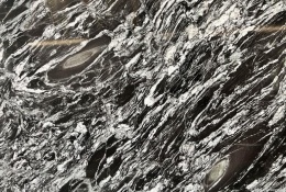 Zbliżenie struktury granitu Oscuro Mist, kontrastowe czarno-białe żyły tworzące dynamiczny, falisty wzór