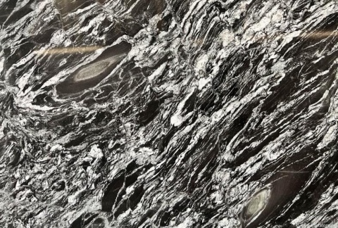 Zbliżenie struktury granitu Oscuro Mist, kontrastowe czarno-białe żyły tworzące dynamiczny, falisty wzór
