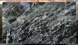 Płyta granitu Oscuro Mist poler, czarno-biały falisty wzór z wyraźnym połyskiem, widok całej tafli w hali