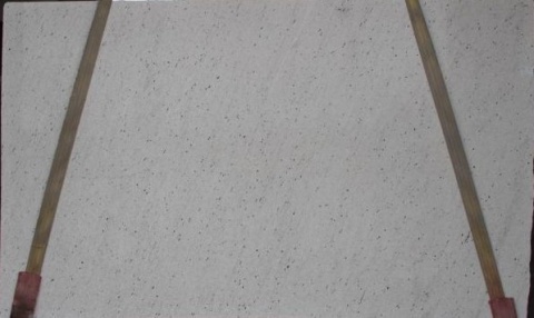 Płyta granitu Perfect White poler, jasna powierzchnia z drobnymi szarymi punktami, widok całej tafli w hali