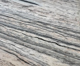 Zbliżenie granitu Prada Gold, dynamiczne złoto-szare pasma z kontrastującymi ciemnymi liniami