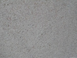 Zbliżenie struktury granitu Rio Branco, równomierna jasnoszara faktura z drobnymi kolorowymi punkcikami