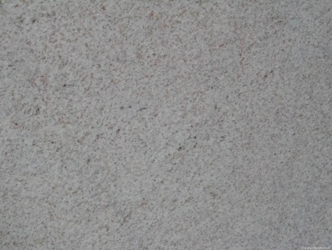 Zbliżenie struktury granitu Rio Branco, równomierna jasnoszara faktura z drobnymi kolorowymi punkcikami